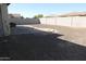 Large gravel backyard with block wall and small patio area at 8808 W State Ave, Glendale, AZ 85305