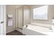 Modern bathroom featuring a glass-enclosed shower, soaking tub, and a bright window for natural light at 8808 W State Ave, Glendale, AZ 85305