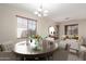 An inviting dining room features a round wooden table set for a meal, complemented by stylish furnishings and natural light at 8808 W State Ave, Glendale, AZ 85305