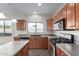 This well-lit kitchen features stainless steel appliances, wooden cabinetry, and a convenient central island at 8808 W State Ave, Glendale, AZ 85305