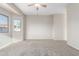 This living room features neutral walls and carpet and windows with a view of the surrounding neighborhood at 8808 W State Ave, Glendale, AZ 85305