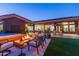 Evening view of backyard with spa, fire pit, and seating at 9771 E Roadrunner Dr, Scottsdale, AZ 85262