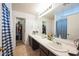 Bathroom featuring a long vanity with a sink and a walk-in closet for ample storage at 14850 W Laurel Ln, Surprise, AZ 85379