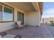 Covered patio with wicker chair and brick pavers at 19122 W Solano Dr, Litchfield Park, AZ 85340