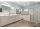 Bright bathroom featuring a dual sink vanity, a soaking tub, and a separate glass-enclosed shower at 19544 W Lincoln St, Buckeye, AZ 85326