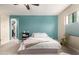 Comfortable bedroom features carpet flooring, teal accent wall, and a view into the ensuite at 19544 W Lincoln St, Buckeye, AZ 85326