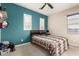 Cozy bedroom with a teal accent wall, plantation shutters and a unique patterned bedspread for a relaxing retreat at 19544 W Lincoln St, Buckeye, AZ 85326