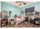 Bedroom with laminate flooring, turquoise walls, and personal items at 19544 W Lincoln St, Buckeye, AZ 85326