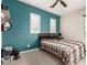 Bright bedroom with teal walls, carpeted floor, and a comfortable bed at 19544 W Lincoln St, Buckeye, AZ 85326