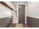 Clean entryway with stylish wood-look flooring, wainscotting, and practical coat rack at 19544 W Lincoln St, Buckeye, AZ 85326