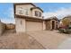 Two-story house with tan exterior, brown accents, and a landscaped yard at 19544 W Lincoln St, Buckeye, AZ 85326