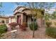 Home's welcoming front exterior with mature landscaping and a charming brick-accented porch at 19544 W Lincoln St, Buckeye, AZ 85326