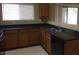 Modern kitchen with dark countertops and wood cabinets at 2636 S Sailors Way, Gilbert, AZ 85295