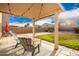 Covered patio with seating area and grassy backyard at 30052 N Desert Willow Blvd, San Tan Valley, AZ 85143