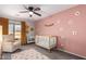 Bedroom featuring a crib, armchair, and pink walls with flower decals at 30052 N Desert Willow Blvd, San Tan Valley, AZ 85143