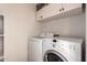 Laundry room with washer, dryer, and overhead cabinets at 30052 N Desert Willow Blvd, San Tan Valley, AZ 85143