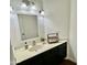 Bathroom vanity with white countertop, black cabinets, framed mirror, and brushed nickel lighting at 4306 E Frye Rd, Phoenix, AZ 85048