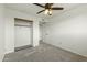 Bright bedroom with ceiling fan, closet, neutral walls, and plush gray carpet at 4306 E Frye Rd, Phoenix, AZ 85048