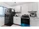 Modern kitchen with white cabinets and black appliances at 5546 W Encanto Blvd, Phoenix, AZ 85035