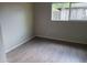 Bright bedroom with wood-look flooring and a window overlooking the backyard at 5839 E Norwood St, Mesa, AZ 85215