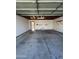 A spacious two-car garage features a concrete floor, open shelving, and an automatic door at 5839 E Norwood St, Mesa, AZ 85215