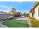 Landscaped backyard with brick patio and artificial turf at 7873 W Fetlock Trl, Peoria, AZ 85383