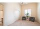 Spacious bedroom with two gray armchairs and double doors at 8537 E Leland St, Mesa, AZ 85207