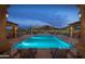 Lighted community pool with lounge chairs and mountain backdrop at dusk at 8537 E Leland St, Mesa, AZ 85207