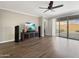 Living area with hardwood floors, sliding glass doors, and a large TV at 9438 W Georgia Ave, Glendale, AZ 85305