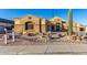 Tan house with three-car garage, desert landscaping, and a large front yard at 10040 E Grandview St, Mesa, AZ 85207