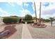 A single-story home with a manicured front yard, palm trees, and a brick walkway leading to the front door at 13359 W Ballad Dr, Sun City West, AZ 85375