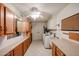 Laundry room offers white cabinets, utility sink, washer, dryer, and neutral tile flooring at 13359 W Ballad Dr, Sun City West, AZ 85375