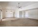 Bright living room featuring neutral paint, a ceiling fan, carpet, and a sliding glass door to the exterior at 13359 W Ballad Dr, Sun City West, AZ 85375