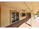 Covered patio with brick pavers leads indoors with sliding glass doors and neutral colored walls at 13359 W Ballad Dr, Sun City West, AZ 85375