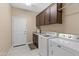 Laundry room with washer, dryer, and upper cabinets at 16807 W Berkeley Rd, Goodyear, AZ 85395