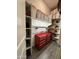 Organized storage room featuring red tool chest, wood crates, shelving, peg board, and gray wood-look tile flooring at 17870 E Appaloosa Dr, Queen Creek, AZ 85142