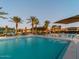 Community pool area with lounge chairs and palm trees at 20385 W Vista Paseo Dr, Buckeye, AZ 85396