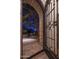 Ornate iron door and arched entry with nighttime lighting at 26872 N 102Nd St, Scottsdale, AZ 85262