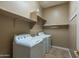 Bright laundry room with washer, dryer, and storage shelves at 4742 S Primrose Dr, Gold Canyon, AZ 85118