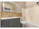 Bathroom with gray vanity, bathtub, and tiled walls at 702 E Nancy Ave, San Tan Valley, AZ 85140