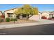 House exterior showcasing a front yard with a tree and drought-tolerant plants at 10051 S 184Th Dr, Goodyear, AZ 85338