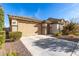 House exterior featuring a two-car garage and well-manicured landscaping at 27227 N 171St Dr, Surprise, AZ 85387