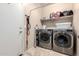 Laundry room with washer, dryer, and storage shelves at 27227 N 171St Dr, Surprise, AZ 85387