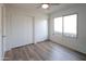 Bright bedroom featuring wood-look laminate flooring and closet storage space at 4709 W Westcott Dr, Glendale, AZ 85308