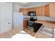 Well-lit kitchen features wood cabinetry, stainless steel appliances, and laminate countertops at 4709 W Westcott Dr, Glendale, AZ 85308