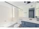 Bathroom with blue vanity, white bathtub and large mirror at 609 W Grandview Rd, Phoenix, AZ 85023