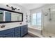 Elegant bathroom with blue vanity, soaking tub, and walk-in shower at 609 W Grandview Rd, Phoenix, AZ 85023