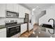 Modern kitchen with white cabinets, stainless steel appliances, and dark countertops at 7423 W Cavalier Dr, Glendale, AZ 85303