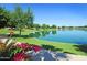 Scenic lakefront view with lush landscaping and walking path at 9542 E Sunridge Dr, Sun Lakes, AZ 85248