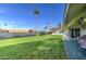 Large grassy backyard with patio and seating area at 10113 W Kingswood Cir, Sun City, AZ 85351